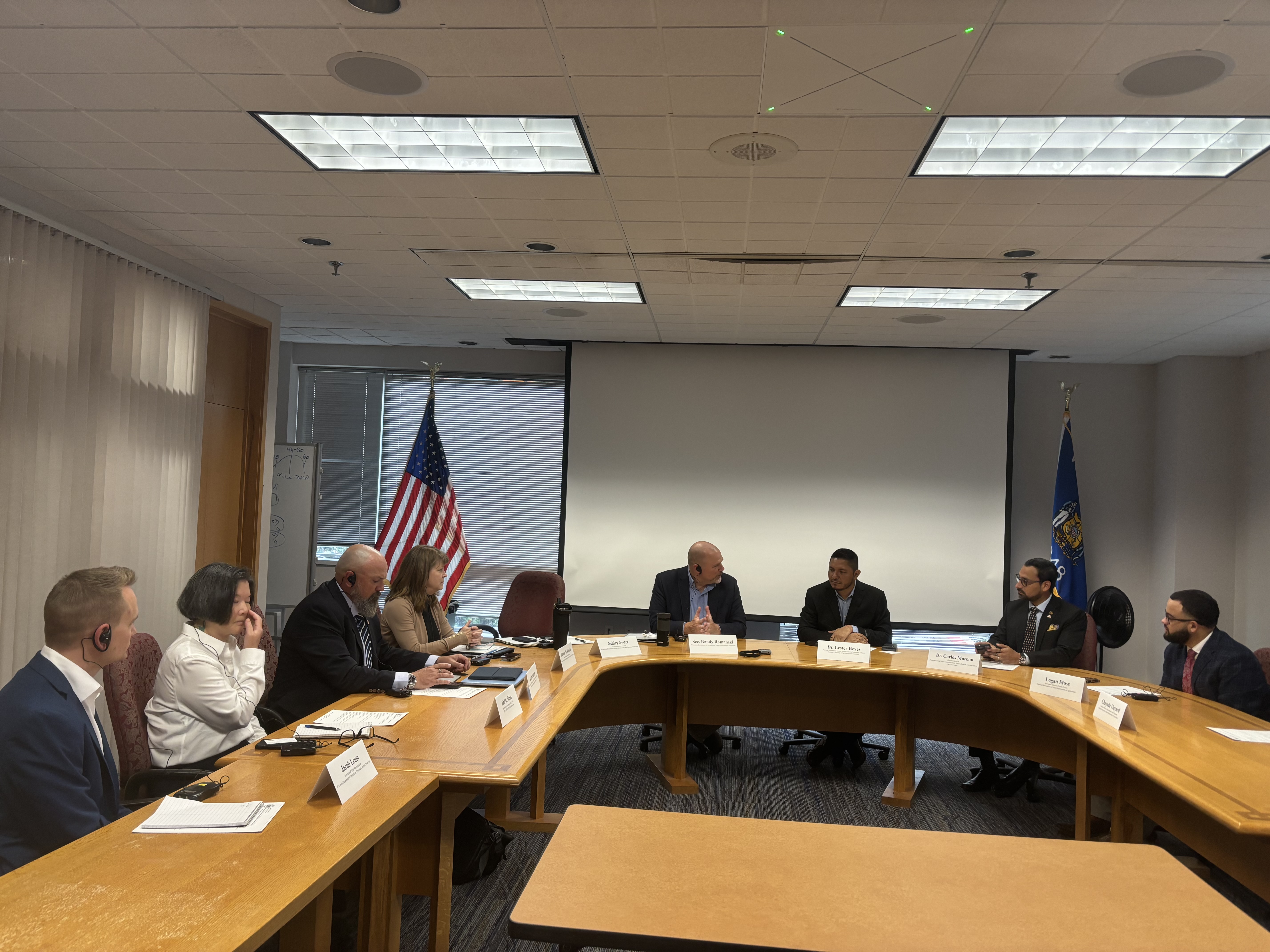 Representatives gathered around board room tables in discussion.