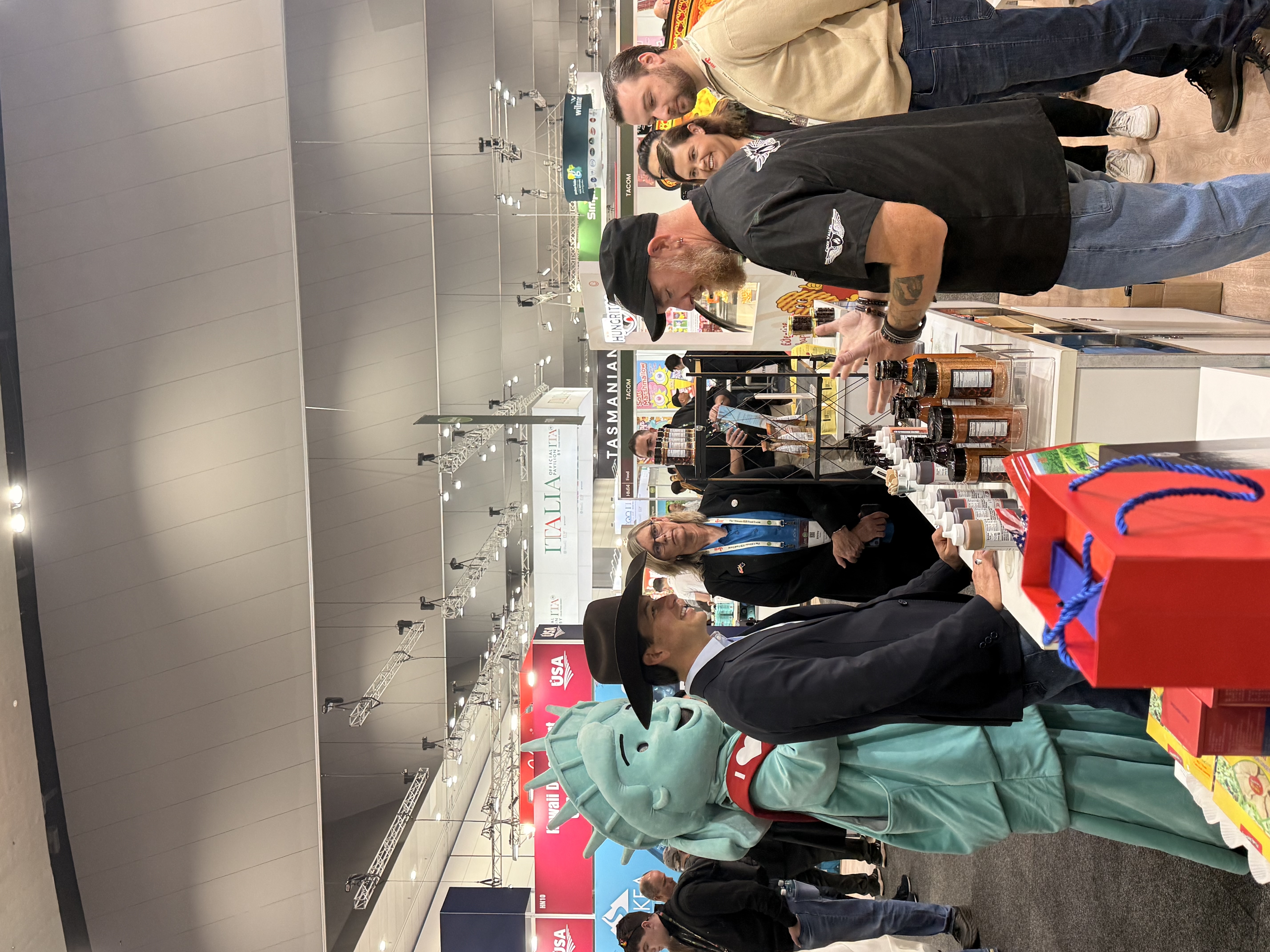Man smiles at the man behind the counter at the BBQ section of the Wisconsin booth.